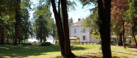 A house with a garden, surrounded by trees.