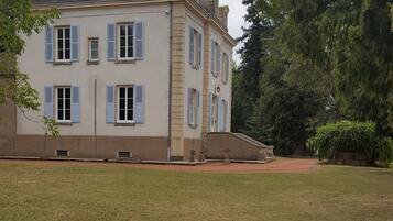 Un grand bâtiment à deux étages, doté d’une façade symétrique, d’une entrée centrale et d’un petit jardin à l’avant.