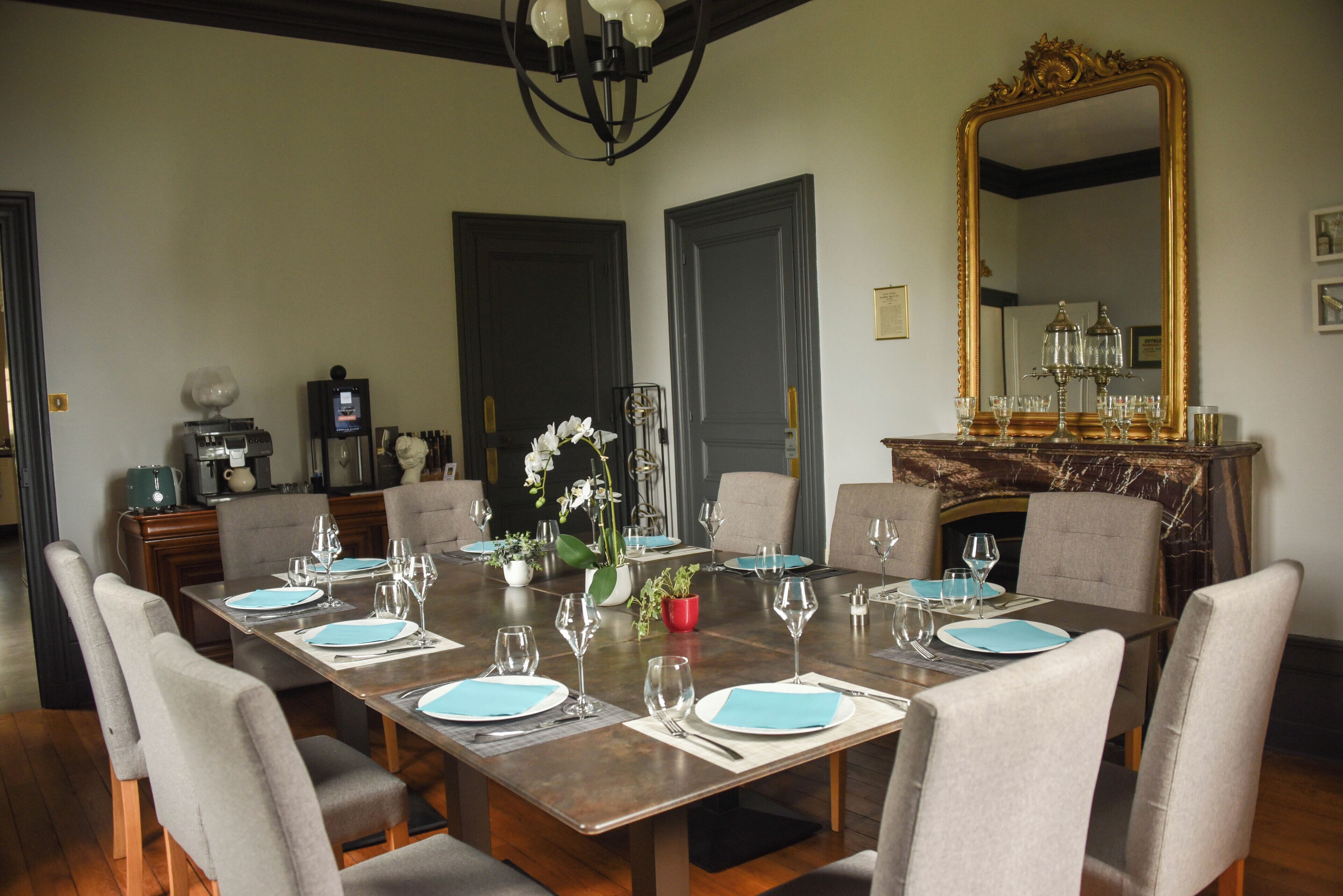 A dining room with a large rectangular table set for six, surrounded by six chairs.