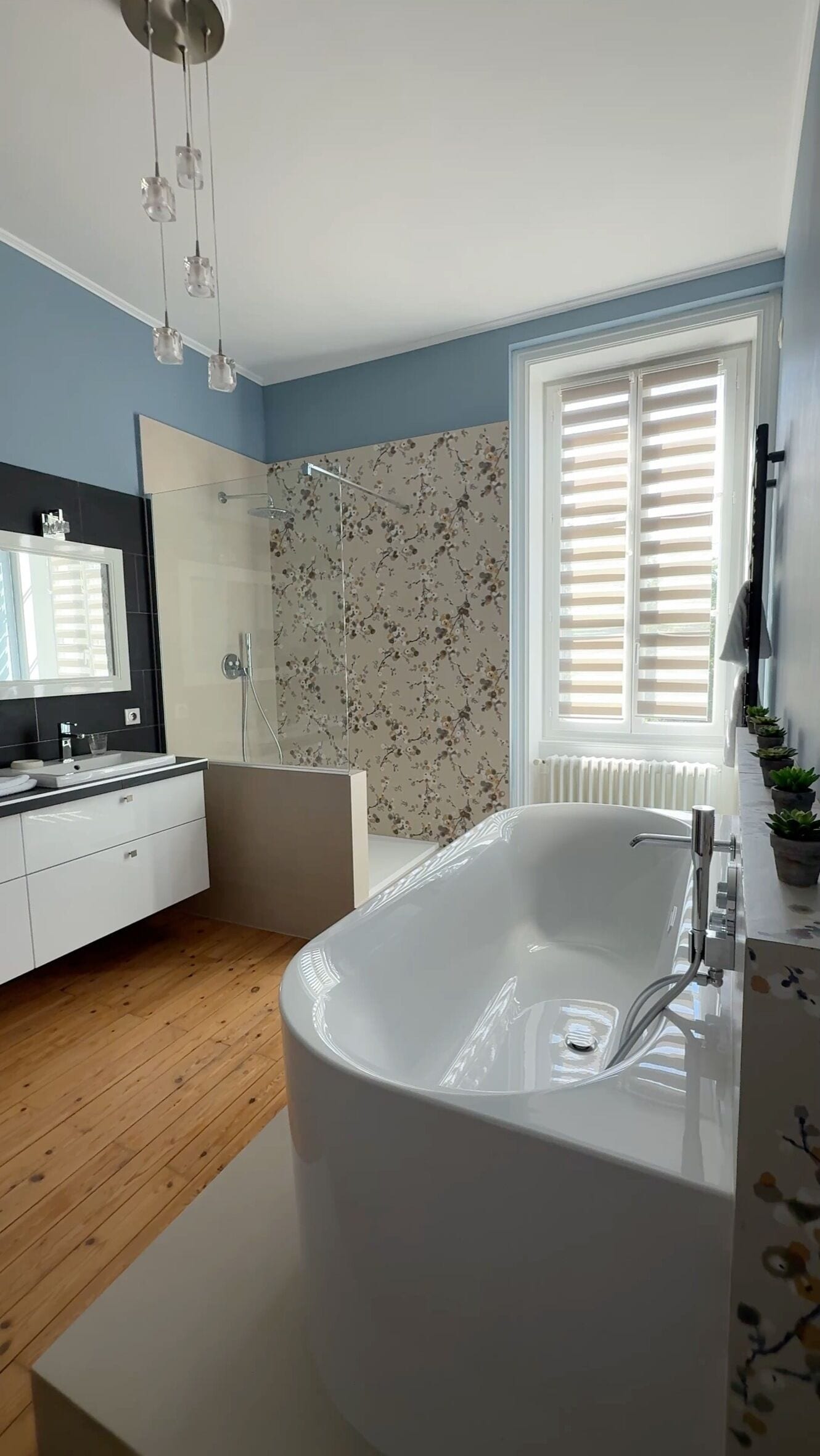 Un baño moderno con una bañera independiente, un espejo grande y una zona de ducha.