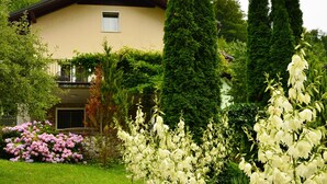 A house with a garden featuring white flowers and pink bushes. - Villa Home & Garden Lasko (Lasko)