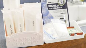 A bathroom counter with a hairbrush holder, a facial essence mask package, and a tray with various toiletries.
