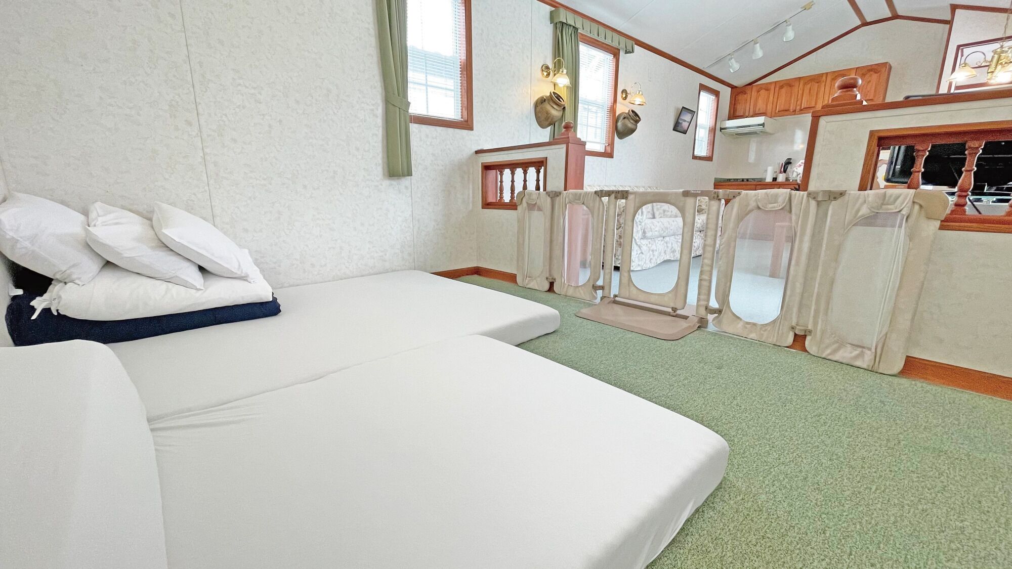 Ein Zimmer mit Bett, einer kleinen Küchenzeile und Blick durch ein Fenster.