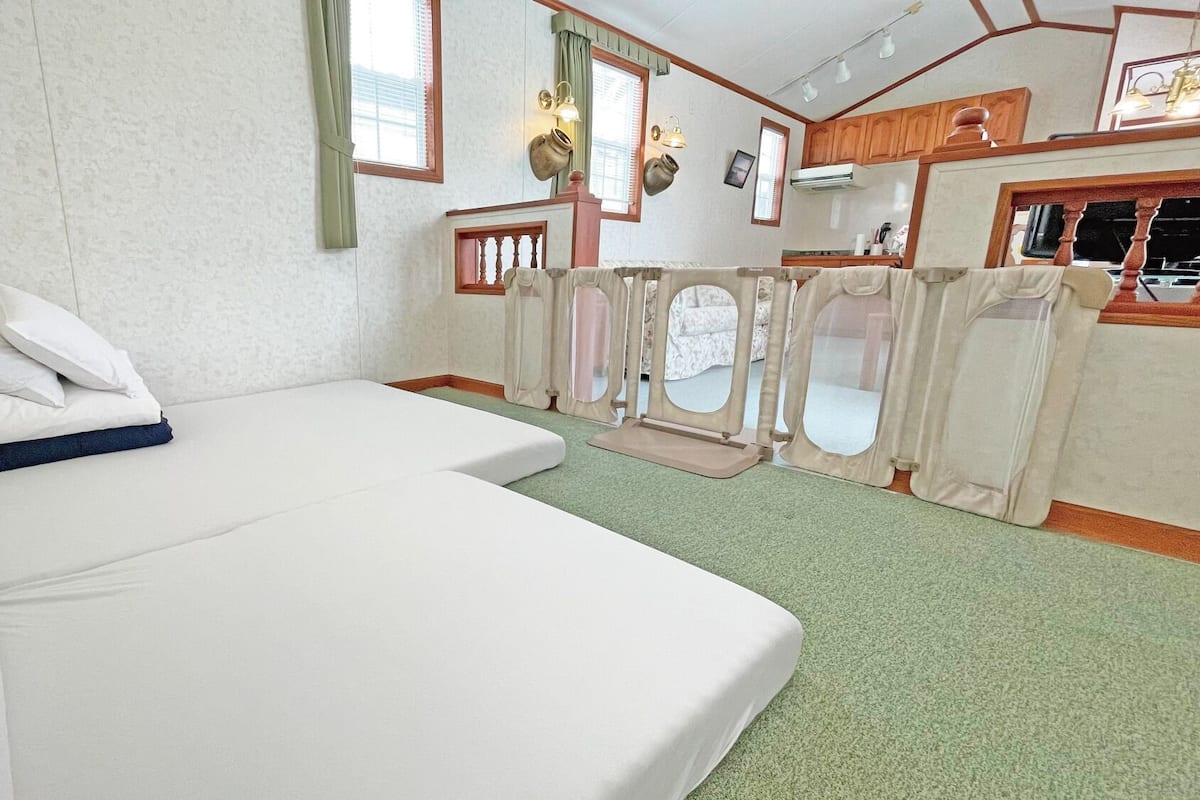 Une chambre avec un lit, un petit coin cuisine et une vue par la fenêtre.