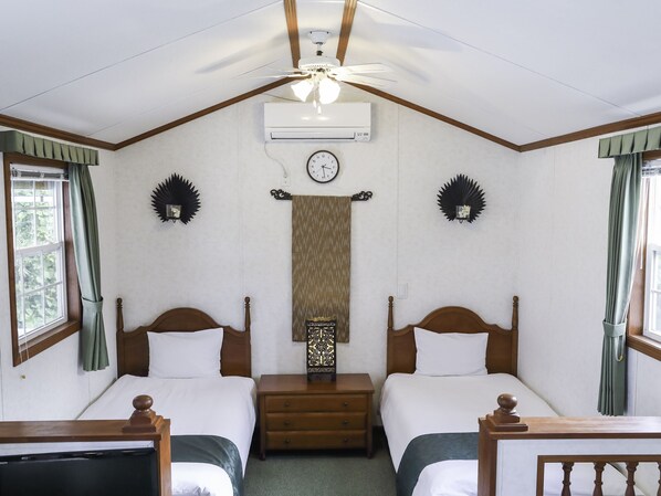 A hotel room with two single beds, a ceiling fan, an air conditioning unit, a clock, and decorative wall sconces. - Cottage Star House Nakijin (Nakijin)