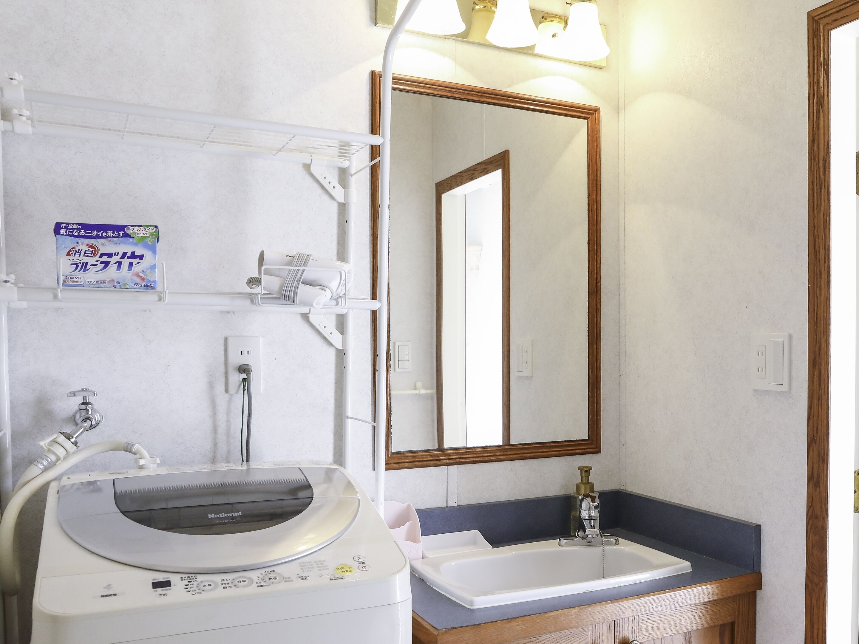 Un bagno con lavandino, specchio e lavatrice.