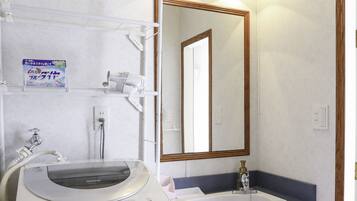 Un bagno con lavandino, specchio e lavatrice.