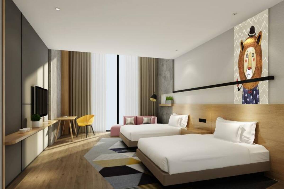 Une chambre d’hôtel moderne équipée de deux lits, d’un bureau, d’une chaise et d’une grande œuvre d’art murale.