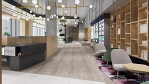 A modern reception area with a black counter, gold hanging lights, and a wooden bookshelf. - Q-Box Hotel Shanghai Nanqiao (Shanghai)