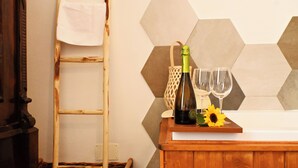 A wooden counter with a bottle of champagne, two glasses, and a sunflower. A wicker basket and a wooden ladder are visible in the background. - Sunrise Luxury (Naples)