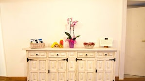 A white cabinet with drawers and a vase with flowers. - Sunrise Luxury (Naples)