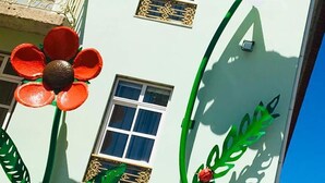 Ein Gebäude mit einer hellgrünen Fassade, zahlreichen Fenstern und Balkonen.