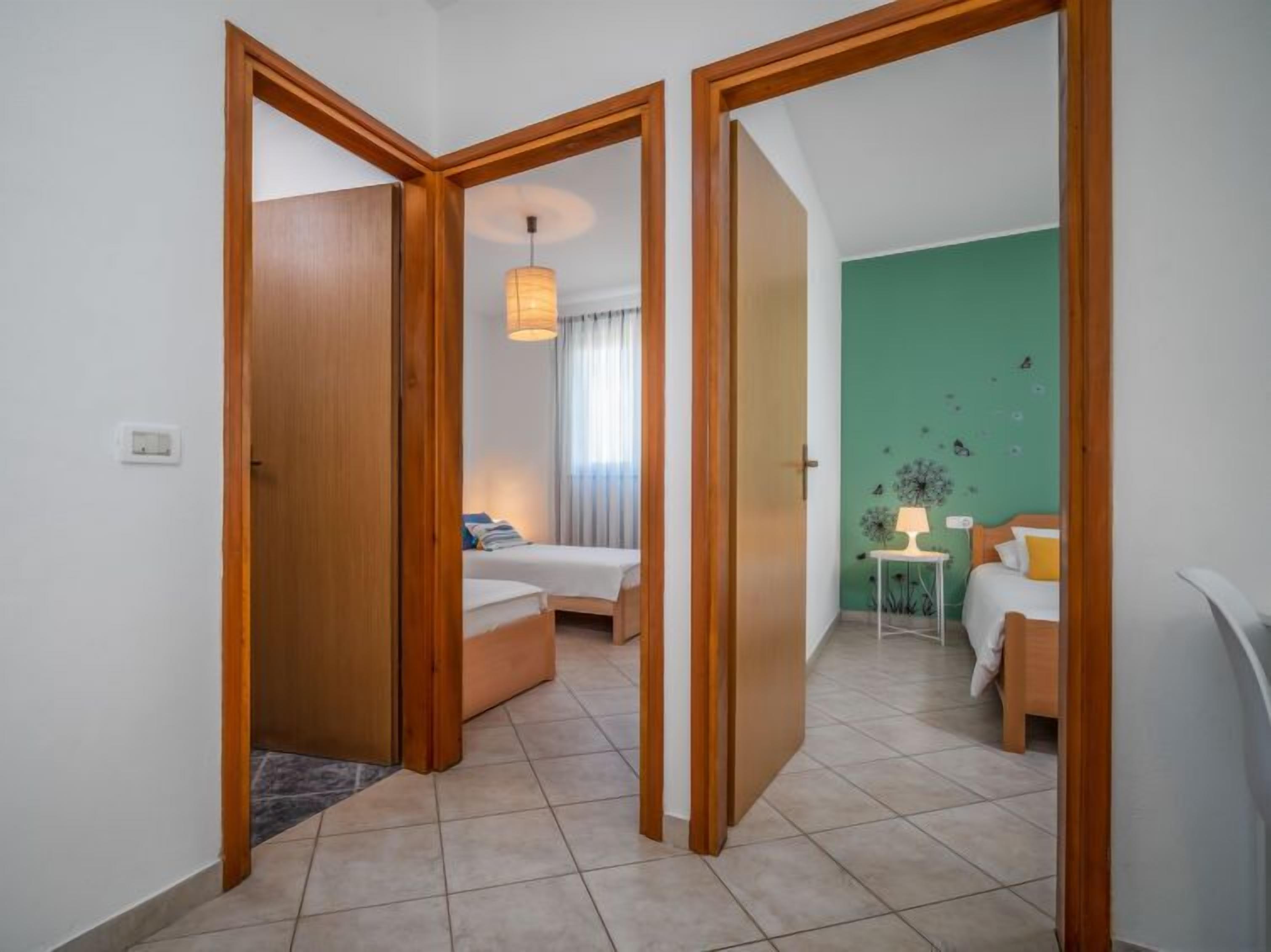 Une chambre d’hôtel avec un lit, une table de chevet, une lampe et un mur d’accent vert.