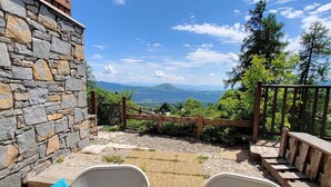 Muro de piedra, cerca de madera y vistas a montañas.