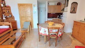 Un espacio habitable compacto con comedor, cocina y un armario de madera.