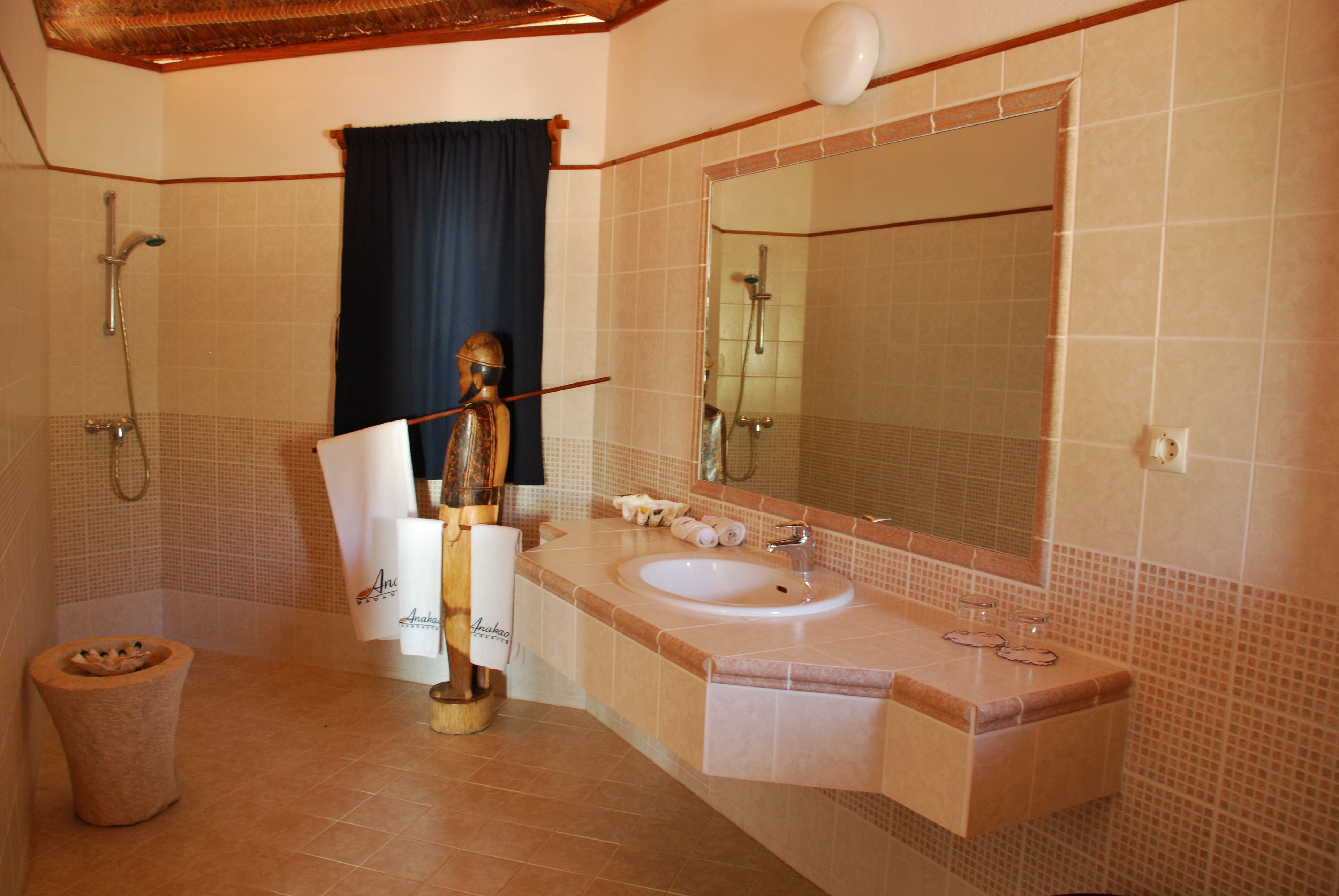 A bathroom with a sink, mirror, shower, and toilet.