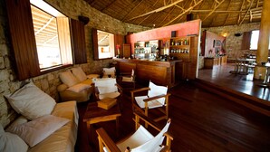 Un interior rústico con paredes de piedra, muebles de madera y una zona de bar.