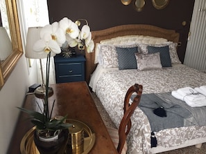 A neatly arranged bedroom with a bed, bedside table, lamp, and decorative items. - B&B Colombo (Mestre)