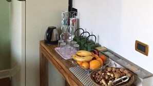 A kitchen with a vintage refrigerator, a clock, a wooden table with fruits, nuts, and a kettle. - B&B Colombo (Mestre)