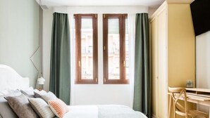 A bedroom with a bed, pillows, a desk, and a chair. - B&B Colombo (Mestre)