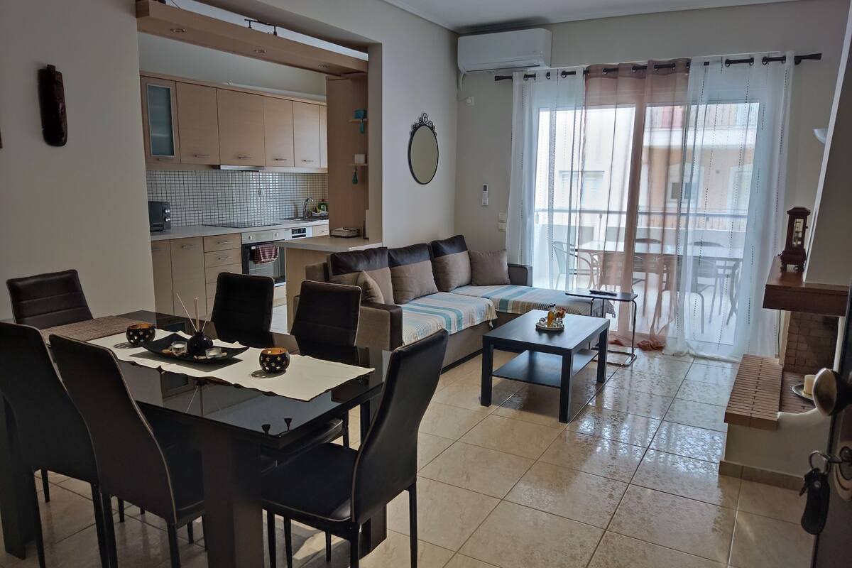Een moderne woonkamer met een eetgedeelte, een keuken en een balkon met uitzicht.