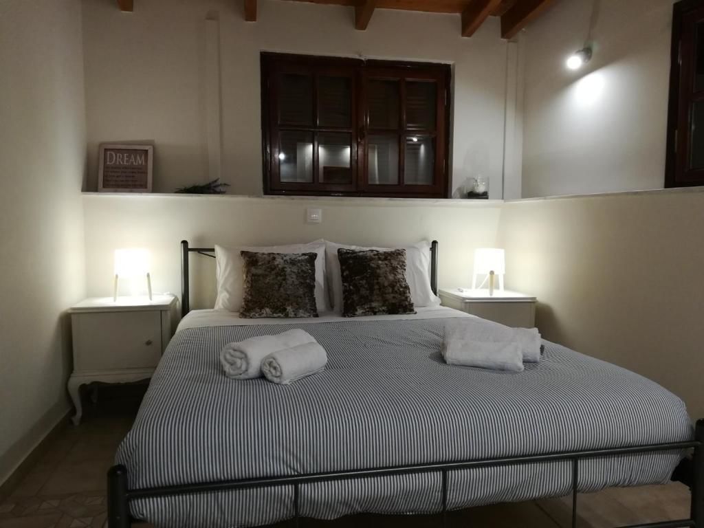 A bedroom with a bed, two bedside tables, a window, and a wall-mounted sign.