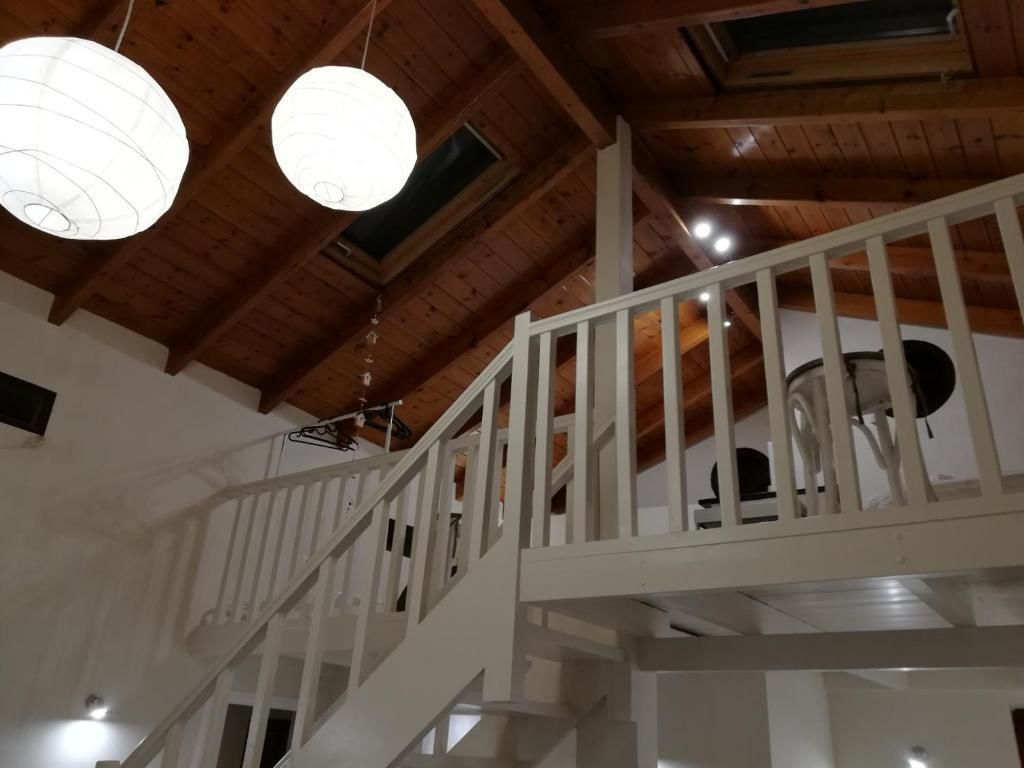 A wooden staircase with white railings leading to an upper level.