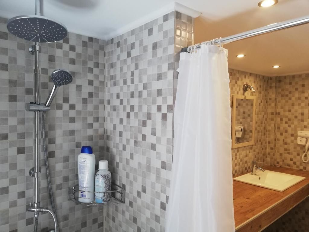 A bathroom with a shower, a sink, and a mirror.