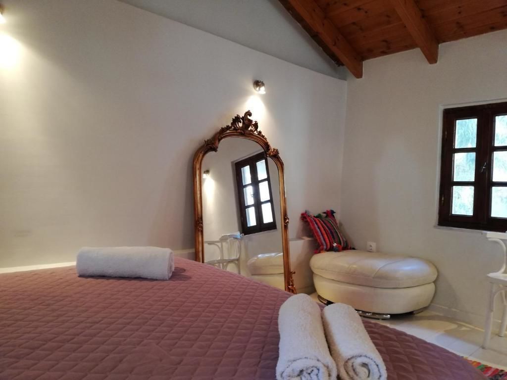 Une chambre d’hôtel avec un lit, un grand miroir, une fenêtre et une petite table.