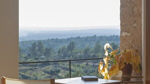A balcony with a table, chairs, and a view of a landscape. - Aldea Roqueta Hotel Rural (Culla)