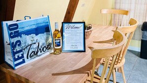 Ein Holztisch mit einem Willkommensschild im Bilderrahmen und einer Weinflasche.