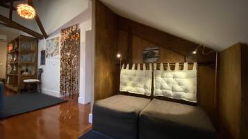 Cozy attic bedroom with a large, cushioned bed and unique headboard design.