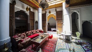 A traditional Moroccan interior with ornate wooden furniture, a patterned floor, and intricate architectural details. - Ryad Zahrat Fes (Fes)