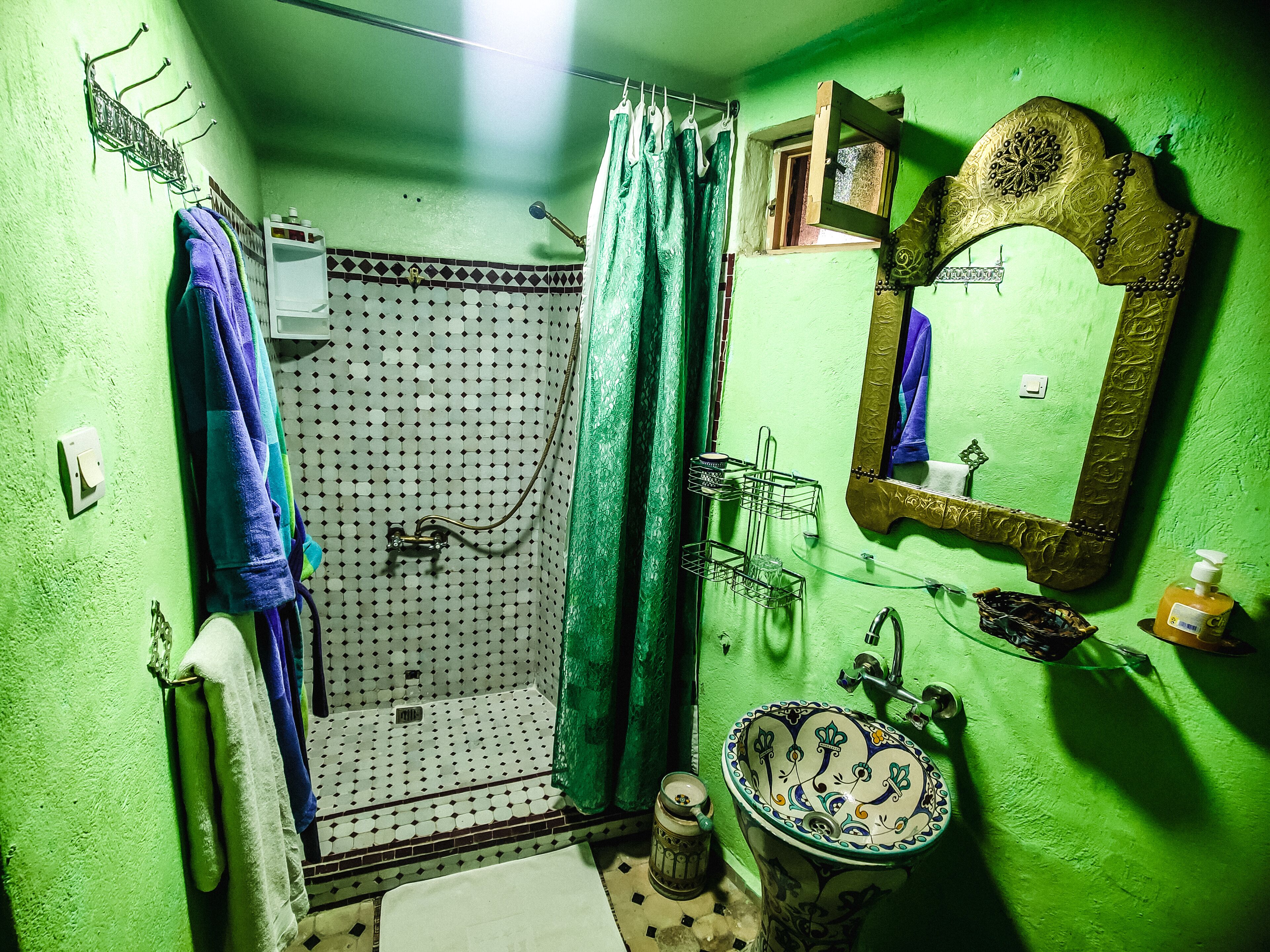 A bathroom with a shower, a sink, and a mirror.