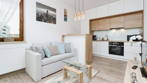 A modern apartment with a living room, kitchen, and dining area. - Modern Apartment | Parking | Close to Tauron Arena (Kraków)