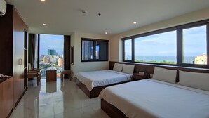 A modern hotel room with two beds, a large window with a city view, a desk, and a wardrobe. - Hong Hai 2 Hotel (Ho Chi Minh City)