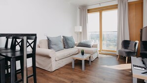 A modern living room with a sofa, coffee table, and dining area. - ShortStayPoland Kolejowa - B10 (Warsaw)