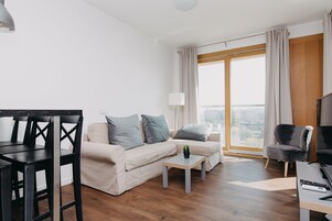 Moderni olohuone, jossa on sohva, sohvapöytä ja ruokailutila.