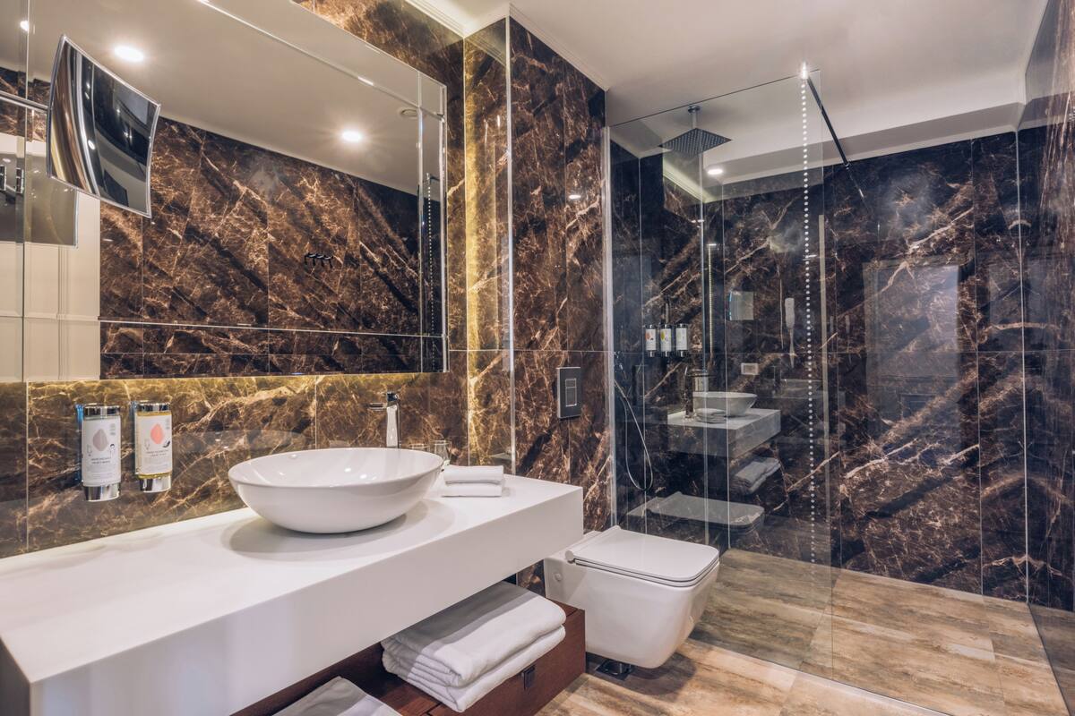 executive single room | bathroom | shower, eco-friendly toiletries, slippers, towels