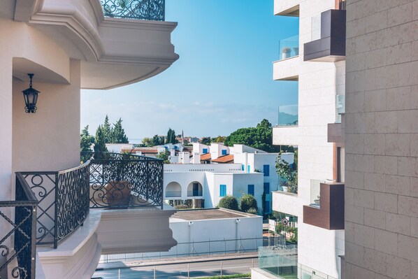 A modern building with balconies, a clear sky, and a view of other buildings in the background. - Iberostar Waves Slavija (Budva)