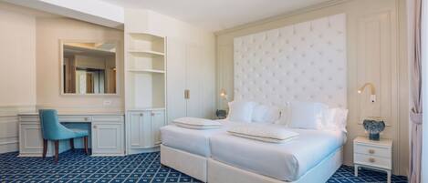 Une chambre d’hôtel avec un grand lit, un bureau et une chaise.