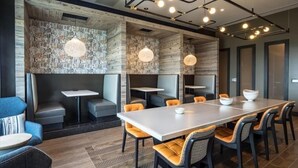 A modern conference room with a long table, multiple chairs, and built-in seating. - Easy Travel to DC | Full Kitchen, Pool & Spa | Downtown Bethesda (Bethesda)