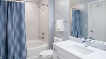 A modern bathroom with a white sink, mirror, and cabinet.