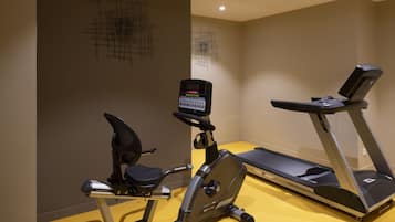 Un gimnasio con una máquina elíptica y una cinta de correr.