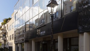 A modern building with a glass facade, a sign reading "37 Lodge," and a street lamp in front. - 37 Lodge La Défense Courbevoie (Courbevoie)