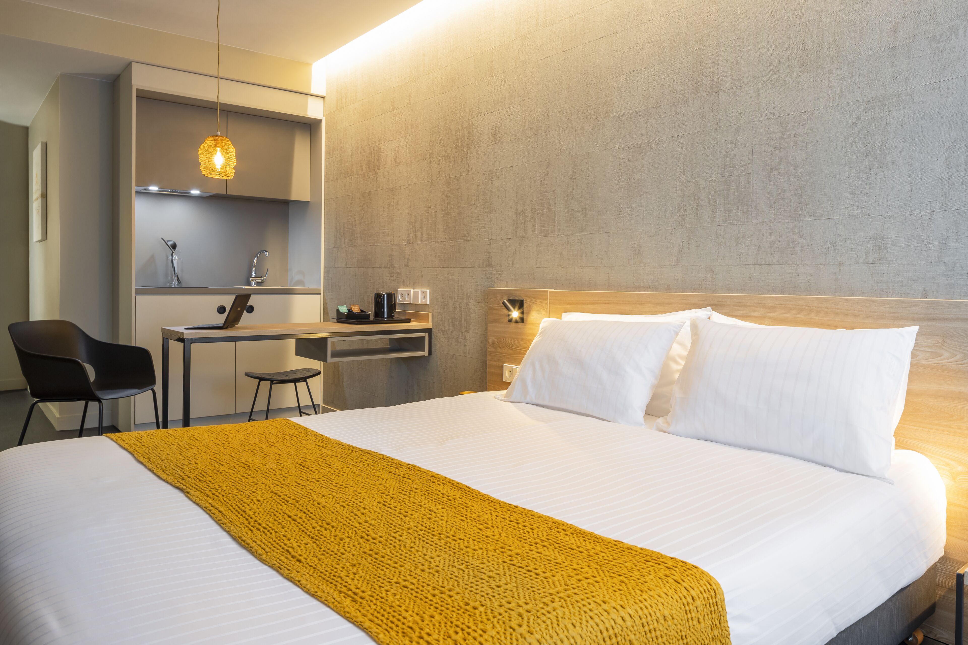 Ein Hotelzimmer mit Bett, Schreibtisch und Stuhl.