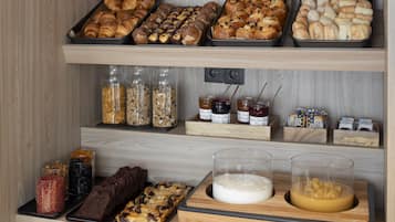 Une vitrine de boulangerie présentant diverses pâtisseries et des pots de confitures et de pâtes à tartiner.