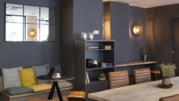 A modern living space with a sofa, a dining table, and a bookshelf. - 37 Lodge La Défense Courbevoie (Courbevoie)
