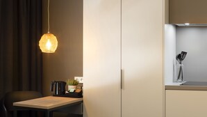 A modern kitchen with a wooden table, a hanging light fixture, a potted plant, and a coffee machine. - 37 Lodge La Défense Courbevoie (Courbevoie)