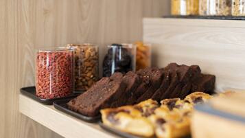 A tray of baked goods and jars of nuts on a wooden surface.